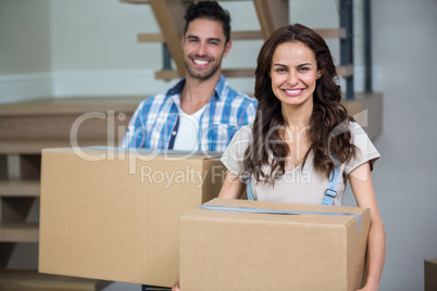 Portrait of smiling couple with cardboard boxes