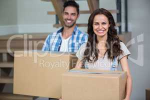 Portrait of smiling couple with cardboard boxes