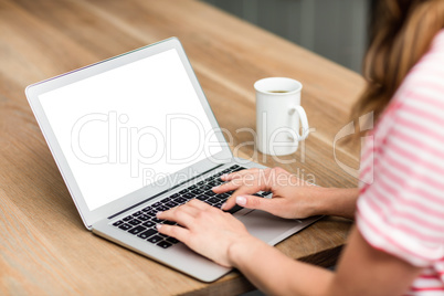 Cropped image of woman typing in laptop