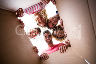 Portrait of cheerful friends seen through cardboard box