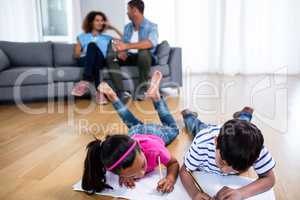 Bother and sister lying on floor and studying