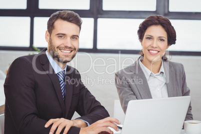 Happy business people with laptop in office