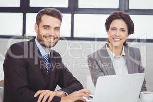 Happy business people with laptop in office