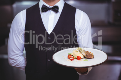 Handsome waiter holding a plate