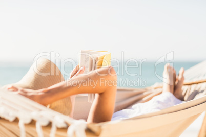 Woman reading book in hammock