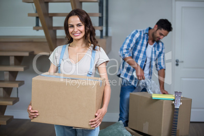 Portrait of smiling woman holding box with man