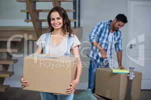 Portrait of smiling woman holding box with man