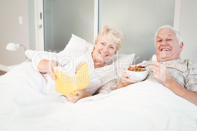 Couple reading book in bed at home