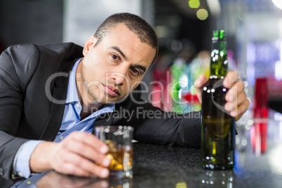 Drunk businessman slumped on bar