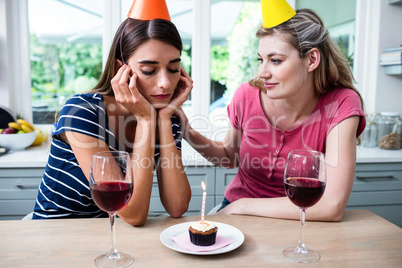 Friend comforting woman during birthday party