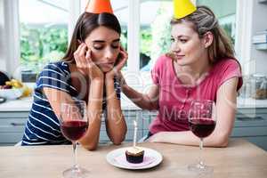 Friend comforting woman during birthday party