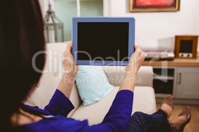 Rear view of woman holding digital tablet