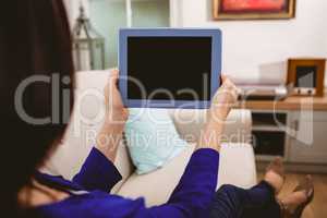 Rear view of woman holding digital tablet