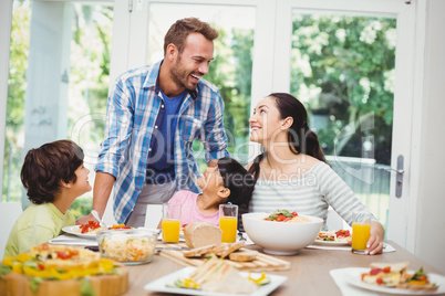 Smiling family discussing at dining table