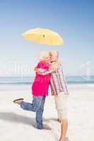 Senior couple kissing and holding umbrella