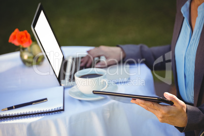 Businesswoman using tablet with coffee