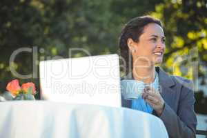 Businesswoman using laptop with coffee