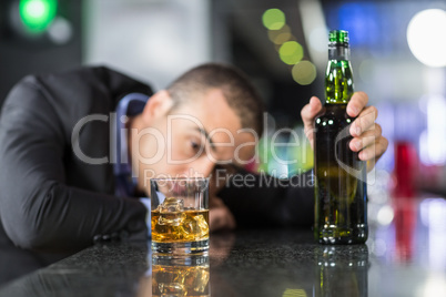 Drunk businessman slumped on bar