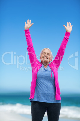 Thoughtful mature woman outstretching her arms