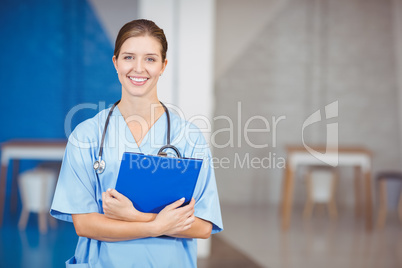 Portrait of beautiful happy female doctor holding clipboard