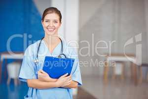 Portrait of beautiful happy female doctor holding clipboard