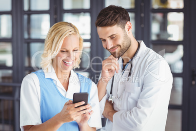 Smiling doctors using mobile phone