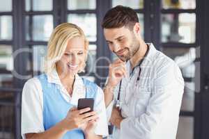 Smiling doctors using mobile phone