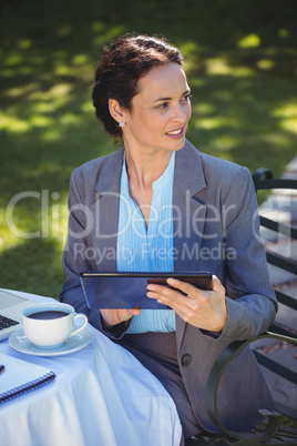 Businesswoman using tablet with coffee