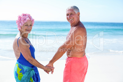 Cute mature couple holding hands on the beach