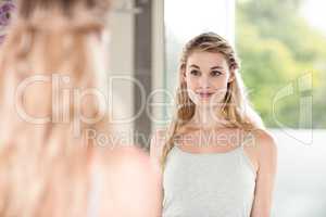 Confident young woman looking in mirror