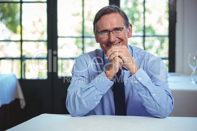 Smiling businessman leaning on a table