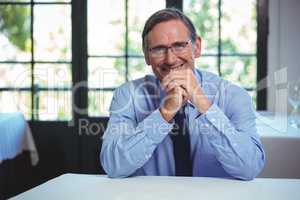 Smiling businessman leaning on a table