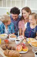 Family smiling while having breakfast at table