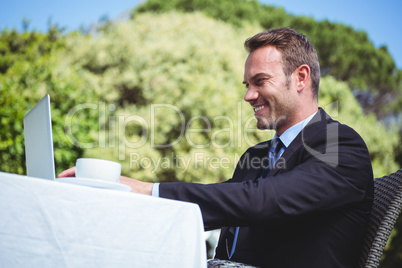 Businessman using laptop and having a coffee