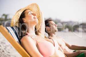 Young couple relaxing on armchair on the beach