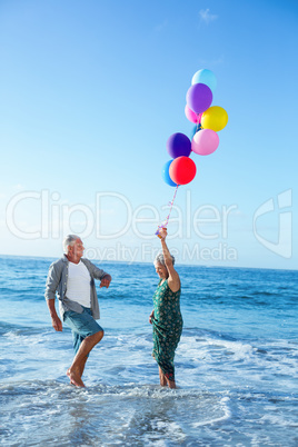 Senior couple holding balloons