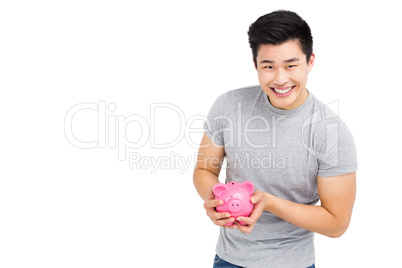 Young man holding a piggy bank