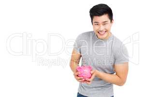 Young man holding a piggy bank