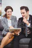 Smiling business professionals using digital tablet