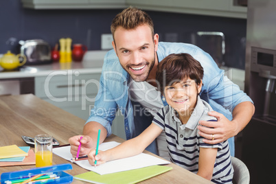 Portrait of father assisting boy in solving maths