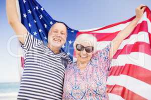 Senior couple holding american flag together