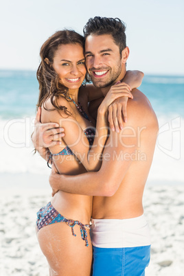 Happy couple hugging on the beach