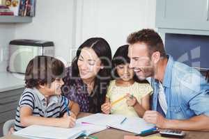 Cheerful parents assisting children in homework