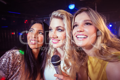 Happy friends singing at the karaoke