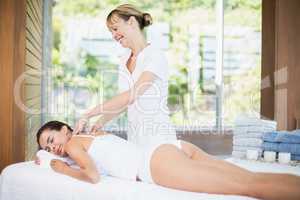 Female masseur massaging beautiful woman at spa