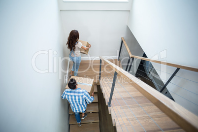 Rear view of couple holding cardboard boxes