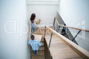 Rear view of couple holding cardboard boxes