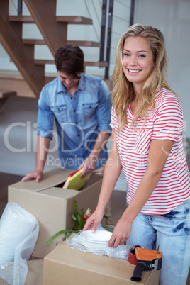 Portrait of woman unpacking bowls from box