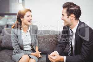 Smiling business people sitting on sofa