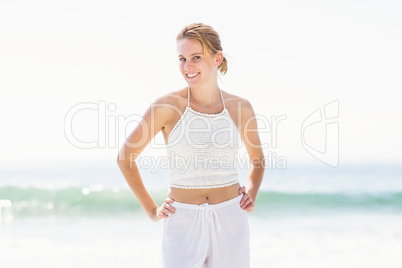 Portrait of pretty woman in white outfit standing on the beach